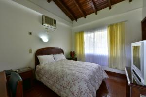 ein Schlafzimmer mit einem Bett und einem TV in der Unterkunft Gran Hotel De Lago - Lago Agrio in Nueva Loja