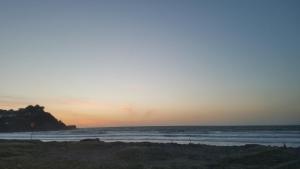 a sunset on a beach with the ocean at SF Ocean View Rentals in Pacifica