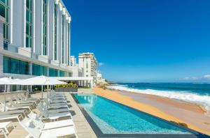 a view of the beach and a swimming pool and the ocean at Condado Ocean Club - Adults Only in San Juan