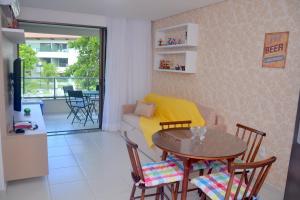 ein Wohnzimmer mit einem Tisch und einem gelben Sofa in der Unterkunft Carneiros Beach Resort in Tamandaré