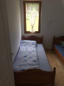 - une petite chambre avec un lit et une fenêtre dans l'établissement Apartment Vila Fila, à Mitrovac