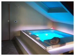 bañera de hidromasaje en una habitación con iluminación en Wellbeing en Milán