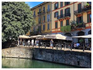 un gruppo di persone che cavalca biciclette su un ponte sopra un fiume di Wellbeing a Milano