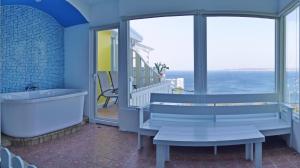 a bathroom with a tub and a balcony with the ocean at 南灣飯店 Kenting Nanwan Hotel in Nanwan