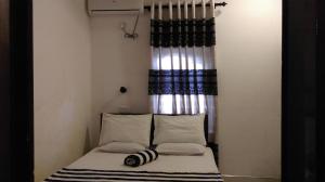ein kleines Bett in einem kleinen Zimmer mit einem Fenster in der Unterkunft Chandra Holiday Home in Dikwella + 65 Fotos