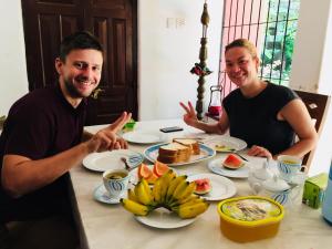 a man and woman sitting at a table with food at Sun Vivanta Resort in Mirissa