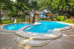 a large swimming pool with blue water in a yard at Santander Pebble Beach Resort in Santander