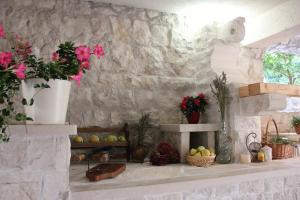 a stone wall with flowers and plants on a counter at Apartments Grgic in Korčula
