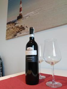 - une bouteille de vin à côté de deux verres à vin dans l'établissement Apartment Sunny Day Gdynia Center, à Gdynia