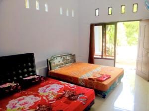 Tempat tidur dalam kamar di Sritanjung Homestay