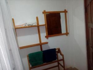 Cette chambre comprend une chaise et un miroir mural. dans l'établissement River Forest Nest, à Ella