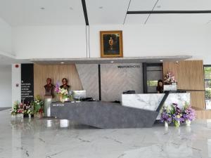 a group of people standing in a lobby with flowers at 9D Sport Hotel in Udon Thani