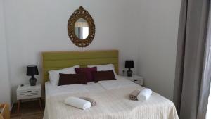 a bedroom with a bed with two pillows and a mirror at Wellness Apartments Ra in Primošten