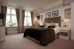 a bedroom with a large bed and two windows at The Marine in Whitstable