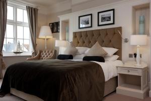 a large bedroom with a large bed with two lamps at The Marine in Whitstable