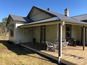 a house with a deck with chairs and a table at Bobby's Country Rental in Eccleston