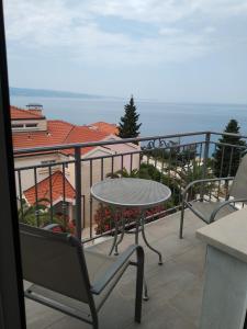 a patio with a table and chairs on a balcony at Sunny Blue apartments in Omiš