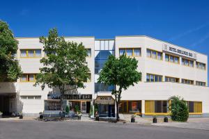 un gran edificio blanco con árboles delante de él en Hotel Berliner Bär en Berlín