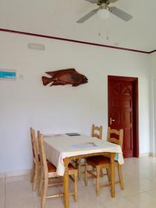 uma sala de jantar com uma mesa e algumas cadeiras em Fadine Self Catering em La Digue