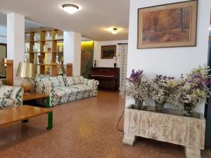 een woonkamer met banken en bloemen in een kamer bij Hotel Marina Playa De Palma in El Arenal