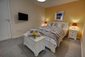 1 dormitorio con 1 cama y TV en la pared en Chapelhill en Helensburgh