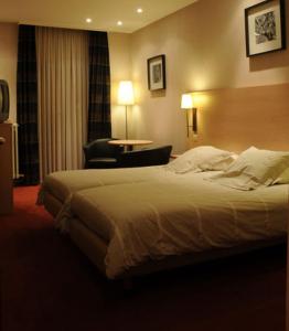 um quarto de hotel com uma cama e uma cadeira em Hotel Escapade em De Haan