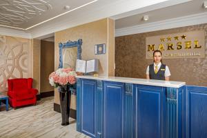 un homme debout au comptoir dans le hall de l'hôtel dans l'établissement Marsel Hotel, à Gelendzhik