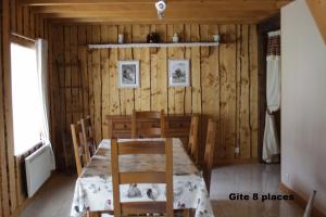 Saulxures-sur-MoselotteにあるGites typiques au coeur des Hautes Vosgesのダイニングルーム(テーブル、椅子付)