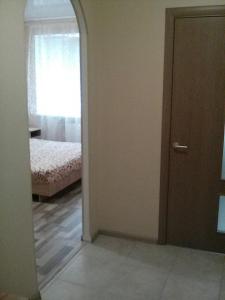 イルピンにあるMineralna Apartment 49のドア付きの部屋、ベッド付きのベッドルーム1室が備わります。