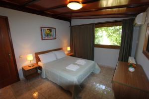 a bedroom with a bed and two lamps and a window at Tosis Apartments in Svoronata