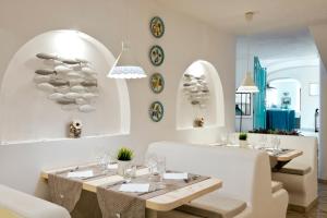 a dining room with white tables and plates on the wall at Hotel Villa Melodie - Adults Only in Ischia