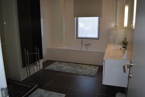 Un baño con bañera, lavabo y bañera. en Vakantiewoning Den Landman, en Nieuwpoort 39 fotos más