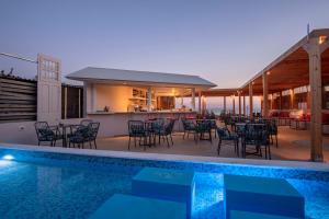 馬拉瑟亞斯的住宿－Armeno Resort，一座带游泳池和桌椅的房屋