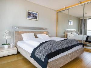 a bedroom with a large bed and a glass wall at VacationClub - Marine Hotel***** Apartment 221 in Kołobrzeg