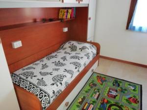 プトゥツ・イドゥにあるApartment The Sea of Sardiniaのベッドとラグ付きの小さなベッドルーム1室が備わります。