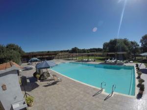 蒙泰菲亞斯科內的住宿－卡潘納山莊農場假日酒店，一个带椅子和遮阳伞的大型游泳池