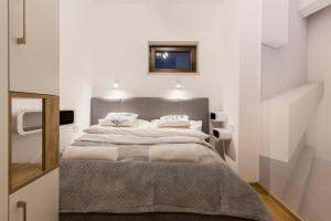 1 dormitorio con 1 cama grande y paredes blancas en Banialuka Apart 693-720-930, en Białka Tatrzanska