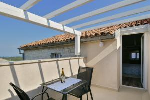 a table with a bottle of wine on a balcony at Apartments Borgo 8 in Tar