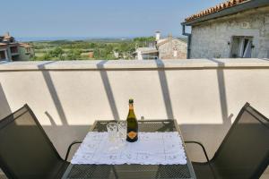 uma garrafa de vinho sentada numa mesa na varanda em Apartments Borgo 8 em Tar