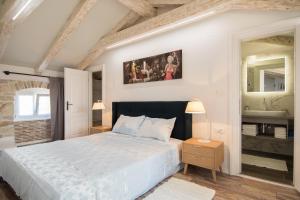 Schlafzimmer mit einem weißen Bett und einem Spiegel in der Unterkunft Apartments Borgo 8 in Tar