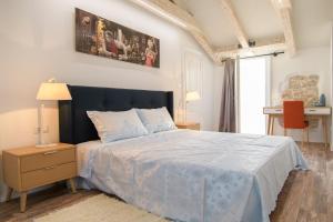 Schlafzimmer mit einem großen Bett mit blauer Decke in der Unterkunft Apartments Borgo 8 in Tar
