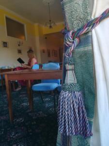 a woman sitting at a table in a room at The Sandhill in Sandown