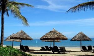a group of chairs and umbrellas on a beach at Minh Apartment in Danang