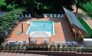 a swimming pool with chairs and a person standing in front of it at Villa Flora in Levico Terme