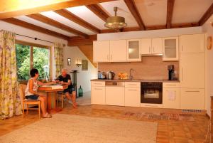 two people sitting at a table in a kitchen at Landhaus Tangern in Millstatt