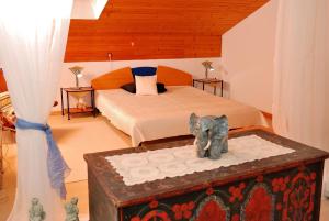 a bedroom with a bed and an elephant statue on a trunk at Landhaus Tangern in Millstatt