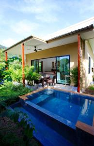 a swimming pool in front of a house at The Great Escape Chalets in Thong Nai Pan Yai