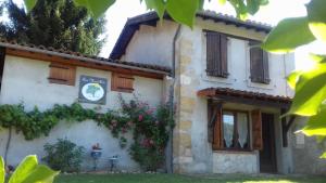 une maison avec des fleurs sur son côté dans l'établissement La Grange, à Le Plan