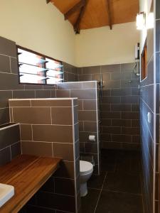 een badkamer met een toilet en een wastafel bij Ko-Sa Beach Resort in Ampeni