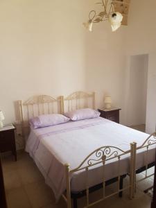 um quarto com uma cama grande e almofadas roxas em Casa Turistica LE SERVITE em Manduria